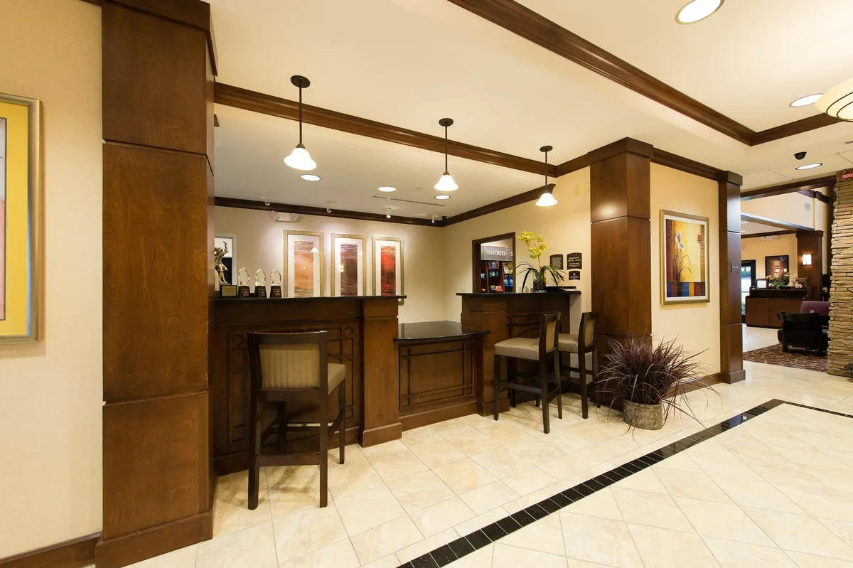 This image captures the inviting reception desk area, complemented by modern artwork, a comfortable seating area, and decorative plants. The ambiance is both professional and welcoming, indicative of attentive guest services available onsite.